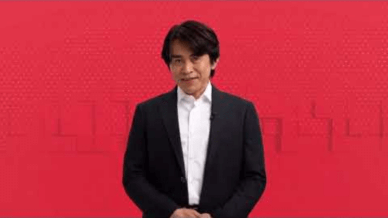 Thumbnail for Felicia and Wynne’s live-streamed reaction of a Nintendo Direct broadcast, featuring a sharply-dressed man standing in front of a red background.